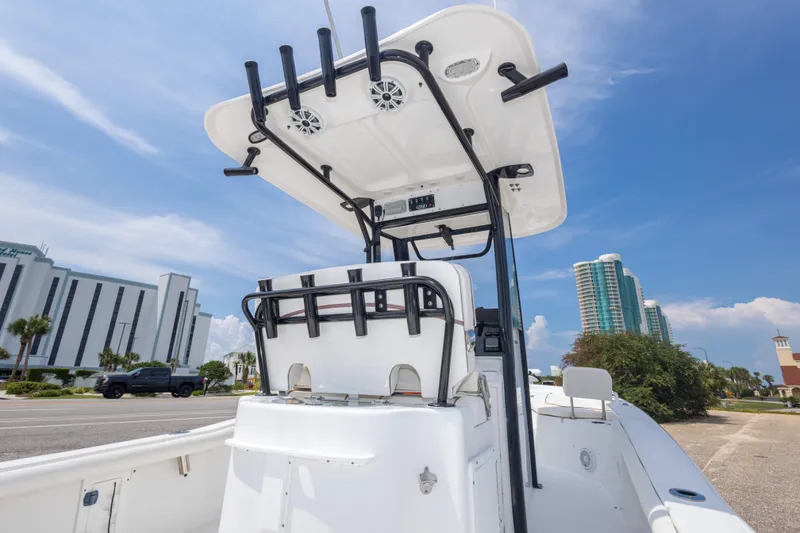 Slide: The Image of 2019 Sea Hunt BX25FS boat with T-top, parked near modern buildings under blue sky. - 28