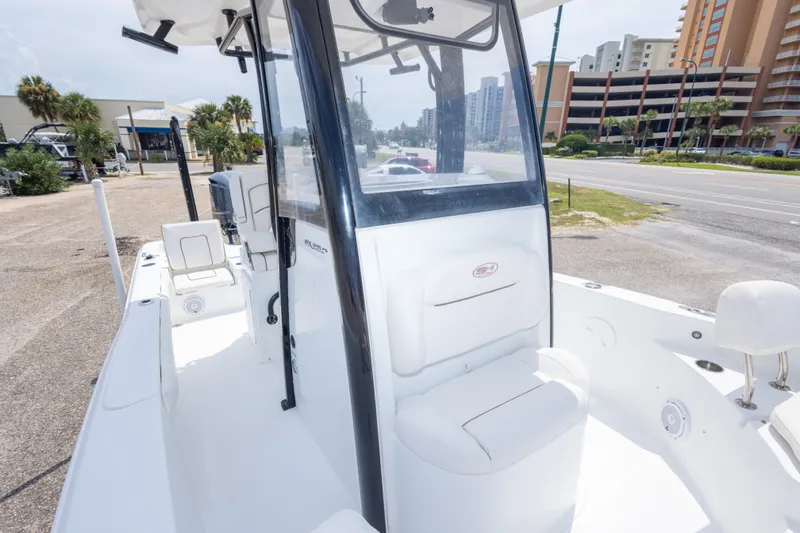 Slide: The Image of 2019 Sea Hunt BX25FS boat with center console, parked near a road and buildings. - 41