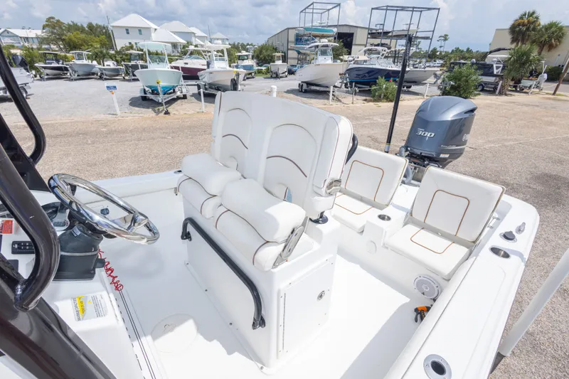 Slide: The Image of 2019 Sea Hunt BX25FS boat interior with seating and steering wheel, parked in marina. - 36