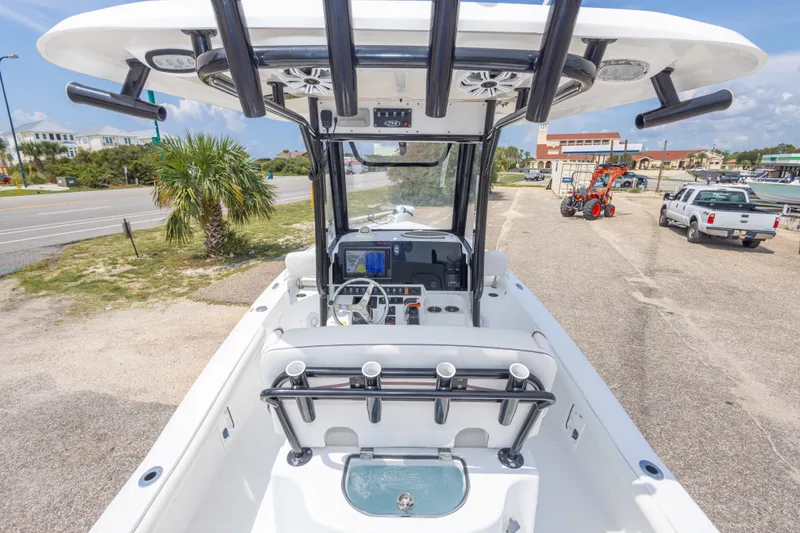 Slide: The Image of 2019 Sea Hunt BX25FS boat interior with steering console and seating, parked near a road. - 51