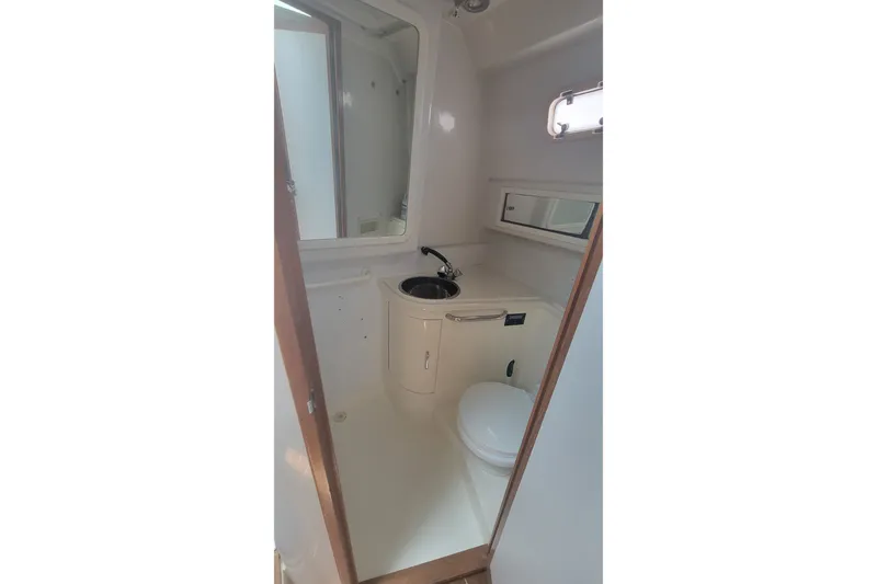Slide: The Image of Compact bathroom in 1995 Cabo 35 Express boat with sink and toilet. - 13
