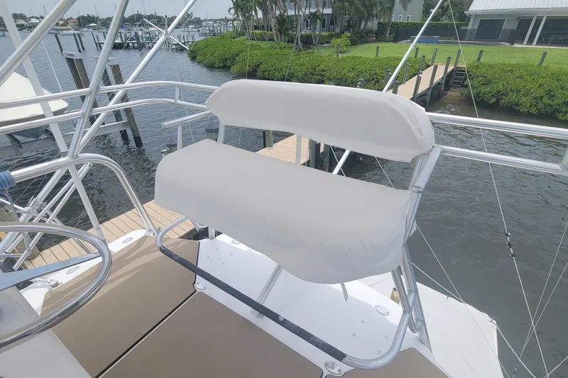 Slide: The Image of Helm seat on 1995 Cabo 35 Express boat, docked by a marina. - 4