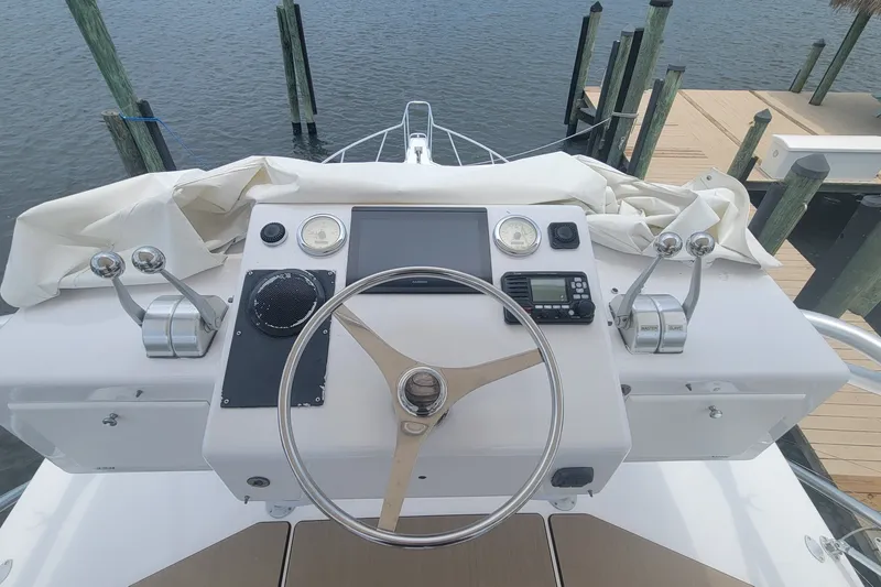 Slide: The Image of Helm of 1995 Cabo 35 Express boat with steering wheel and controls at dock. - 5