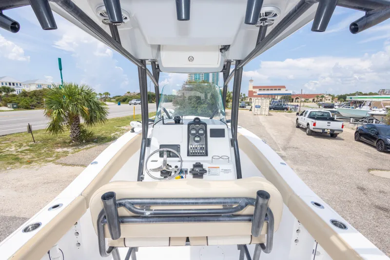 Slide: The Image of 2016 Sea Fox 266 Commander boat interior with steering console and seating, parked near a road. - 47