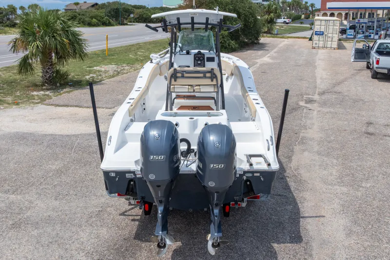 Slide: The Image of 2016 Sea Fox 266 Commander boat with dual Yamaha 150 engines, parked outdoors. - 56