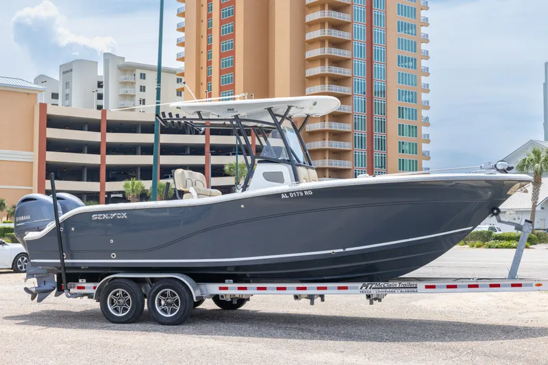 The Image of 2016 Sea Fox 266 Commander boat on trailer, parked near modern buildings. - 0
