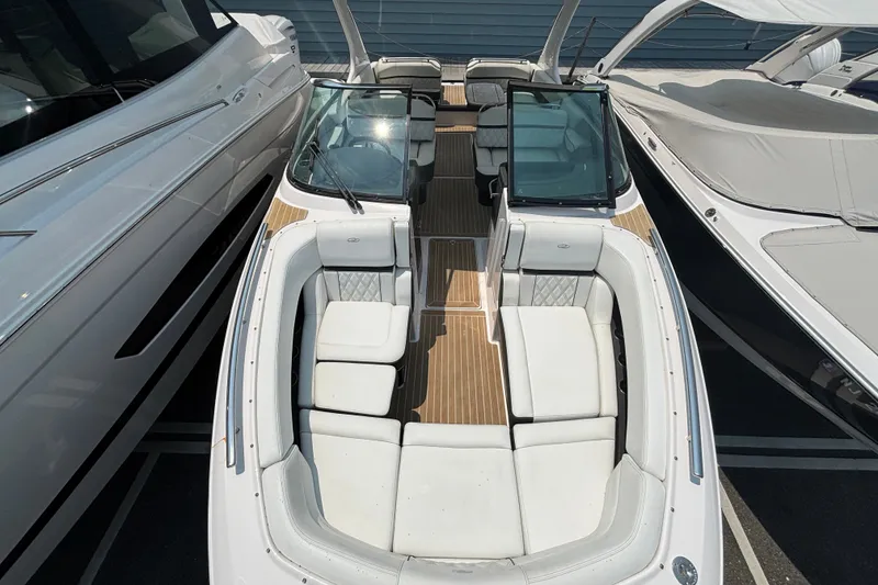 Slide: The Image of 2020 Regal 2800 Bowrider boat with spacious seating and sleek design, docked between other boats. - 6