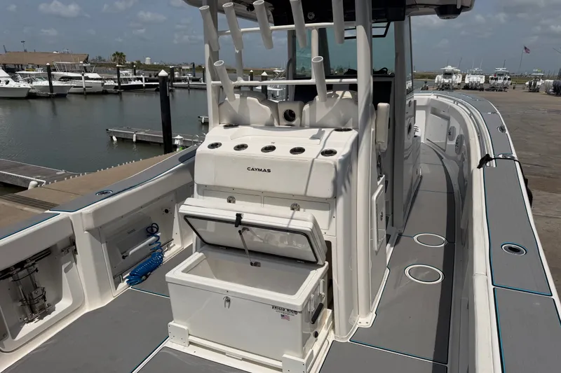 Slide: The Image of 2021 Caymas 341 CC boat docked, featuring spacious deck and storage compartments. - 12