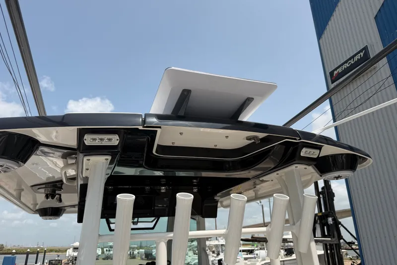 Slide: The Image of 2021 Caymas 341 CC boat roof with rod holders and LED lights, under clear sky. - 61