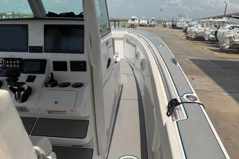 Slide: The Image of 2021 Caymas 341 CC boat interior with modern dashboard and docked at marina. - 14