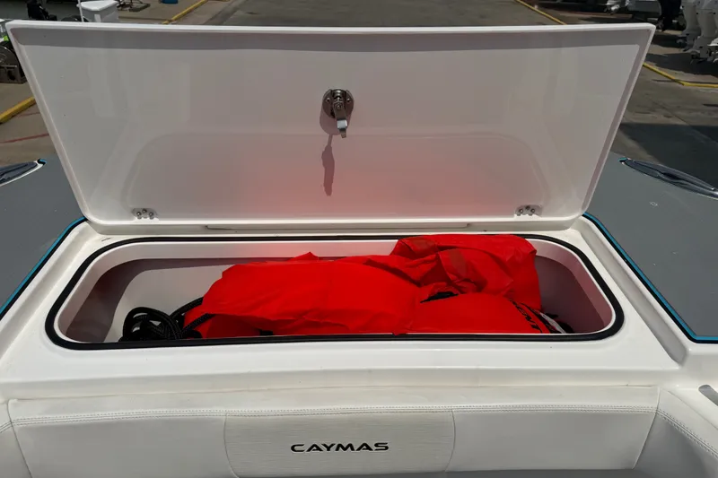 Slide: The Image of Open storage compartment on 2021 Caymas 341 CC boat with red life jackets inside. - 20