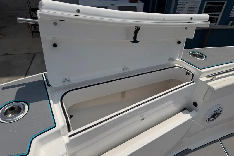 Slide: The Image of Open storage compartment on 2021 Caymas 341 CC boat, featuring sleek design and cup holders. - 24