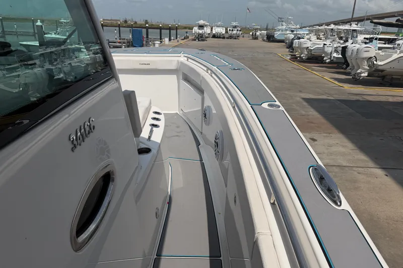 Slide: The Image of 2021 Caymas 341 CC boat docked, showcasing sleek design and spacious deck. - 19