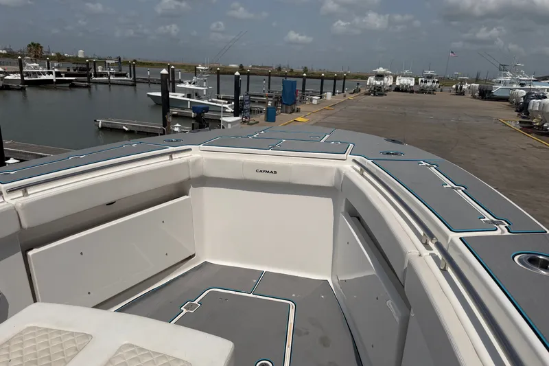 Slide: The Image of 2021 Caymas 341 CC boat docked at marina, showcasing spacious deck and seating area. - 22