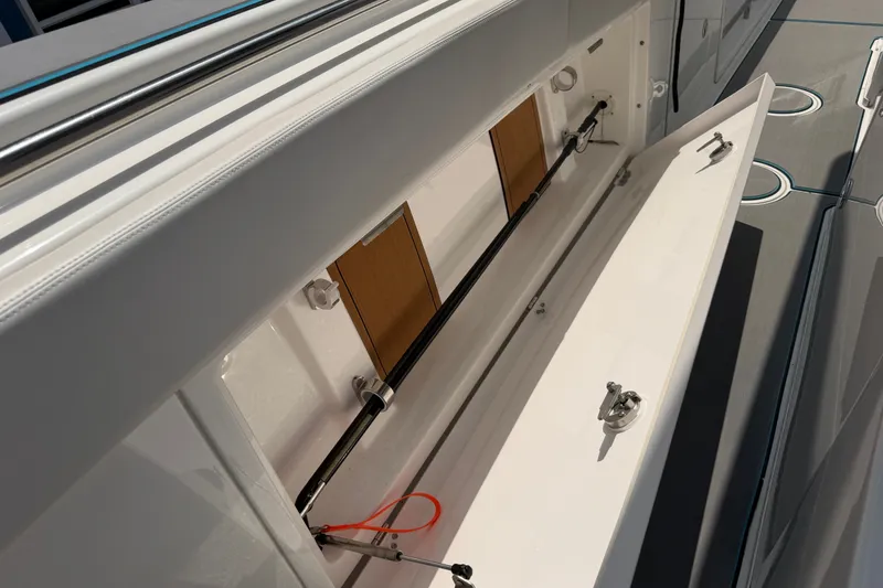 Slide: The Image of 2021 Caymas 341 CC boat storage compartment with open hatch and secure latches. - 34