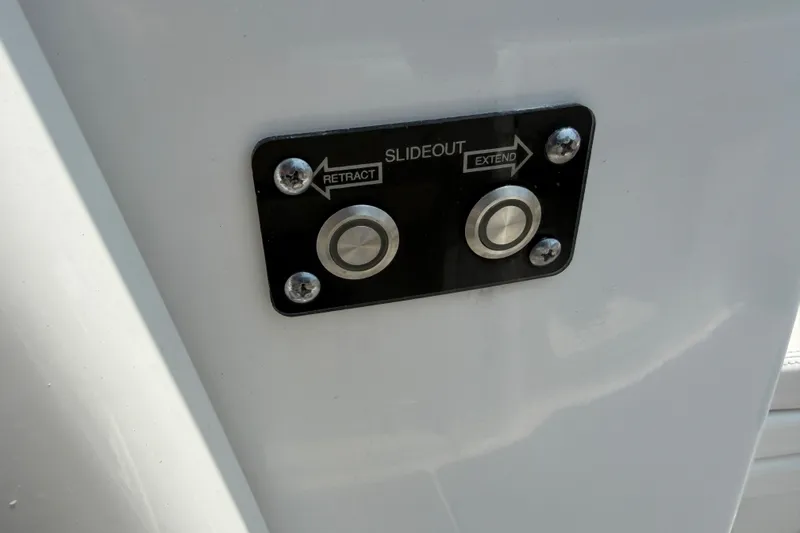 Slide: The Image of Control panel with retract and extend buttons on 2021 Caymas 341 CC boat. - 49
