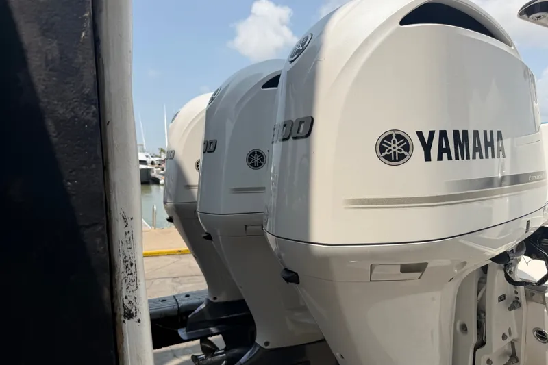 Slide: The Image of Triple Yamaha outboard engines on a 2021 Caymas 341 CC boat at the marina. - 10