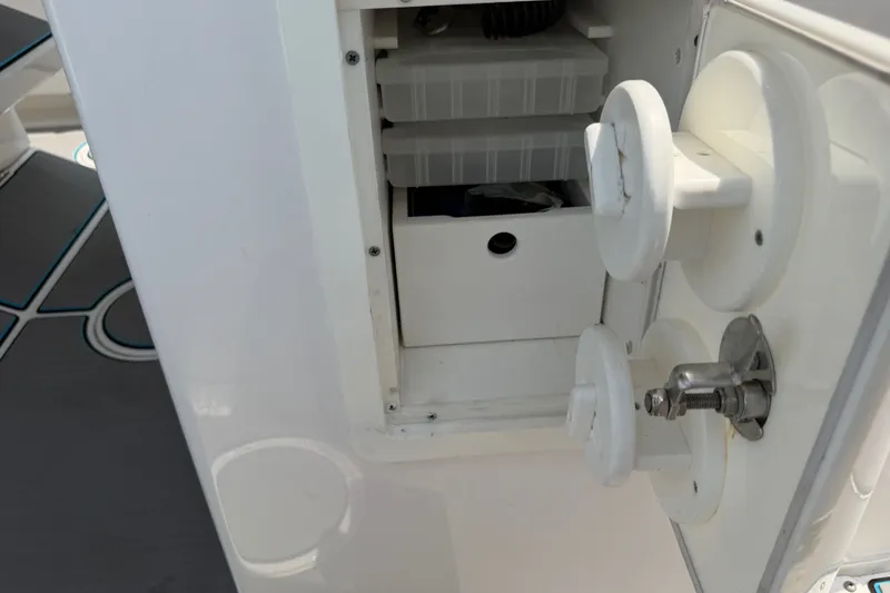 Slide: The Image of Storage compartment on a 2021 Caymas 341 CC boat, featuring organized tackle boxes. - 48