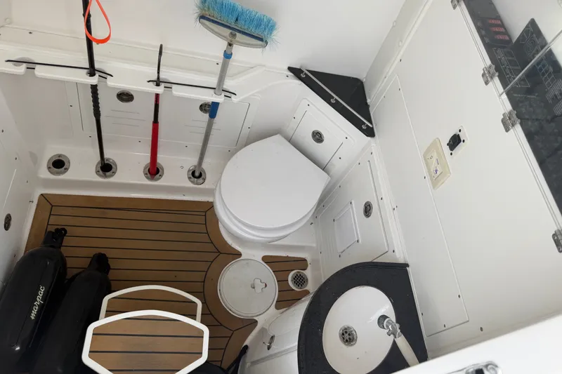 Slide: The Image of 2021 Caymas 341 CC boat interior with toilet, sink, and cleaning tools. - 41