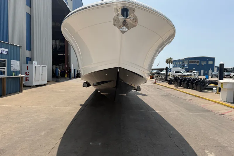Slide: The Image of 2021 Caymas 341 CC boat at a marina, front view, with industrial background. - 5