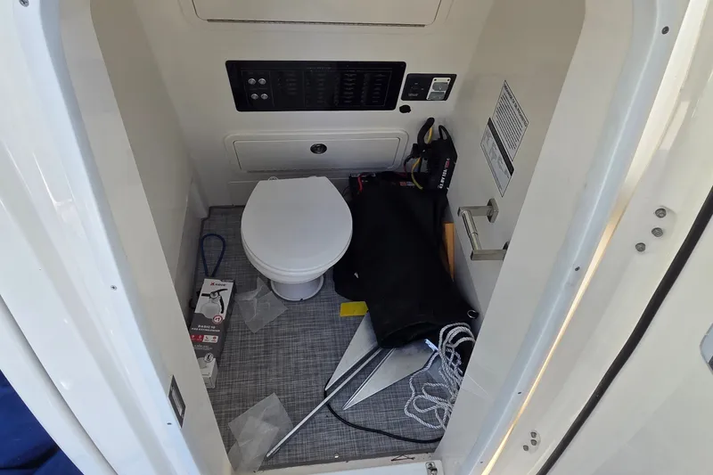 Slide: The Image of Interior of 2025 World Cat 260 CC-X boat, featuring a compact marine toilet. - 35