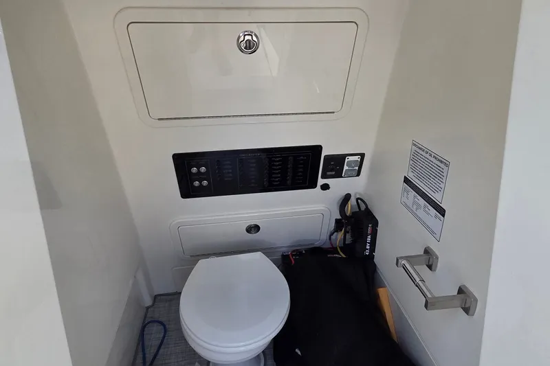 Slide: The Image of Interior of 2025 World Cat 260 CC-X boat featuring a compact marine toilet. - 37