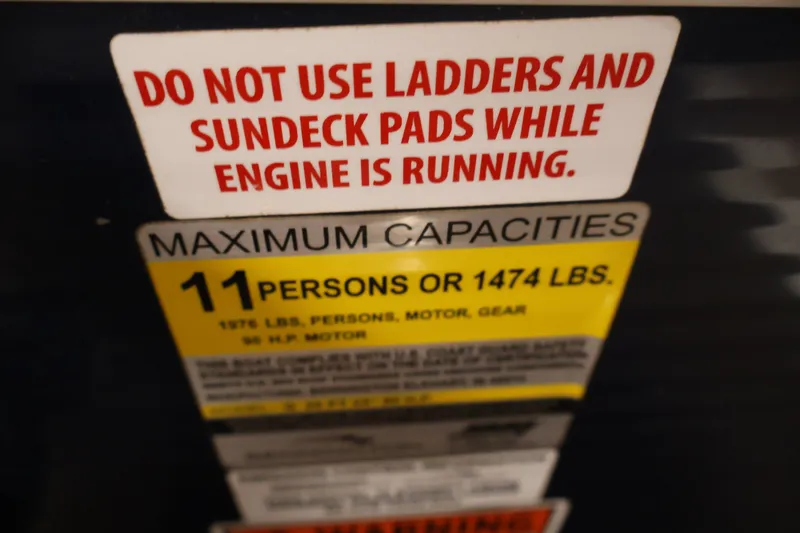 Slide: The Image of Warning labels on 2012 Bennington 2075 GS boat, indicating maximum capacity and safety instructions. - 32