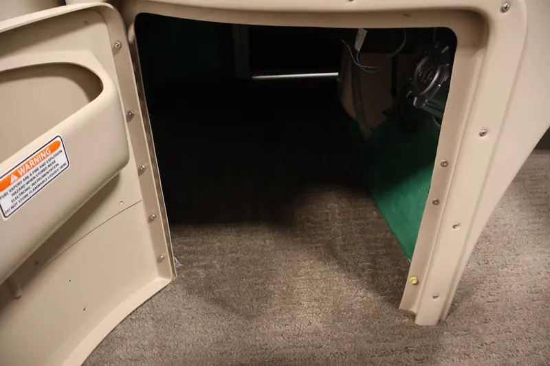 Slide: The Image of Interior view of a 2012 Bennington 2075 GS boat, showing storage compartment and warning label. - 23