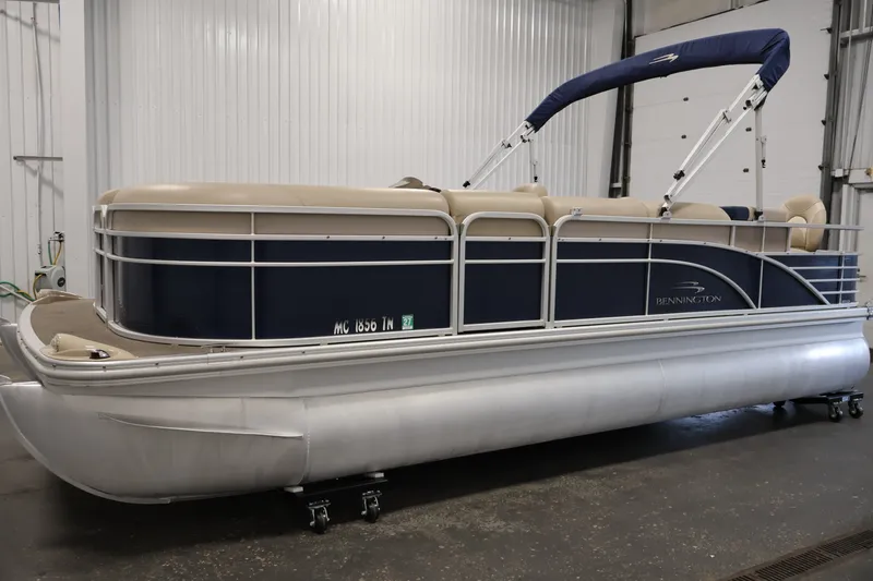 Slide: The Image of 2012 Bennington 2075 GS pontoon boat with blue and beige design in a garage setting. - 8