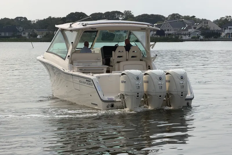 Slide: The Image of 2027 Grady-White Freedom 345 boat with triple Yamaha engines on a calm lake. - 10