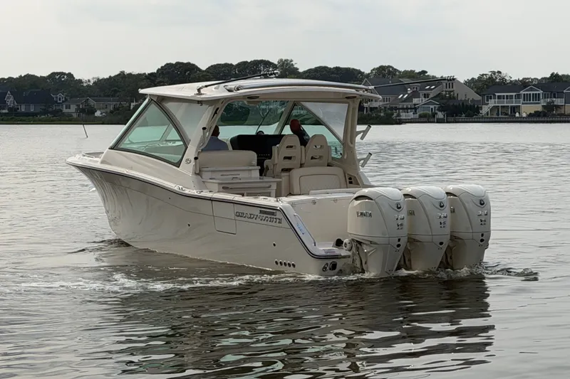 Slide: The Image of 2027 Grady-White Freedom 345 boat with triple engines cruising on calm water. - 8