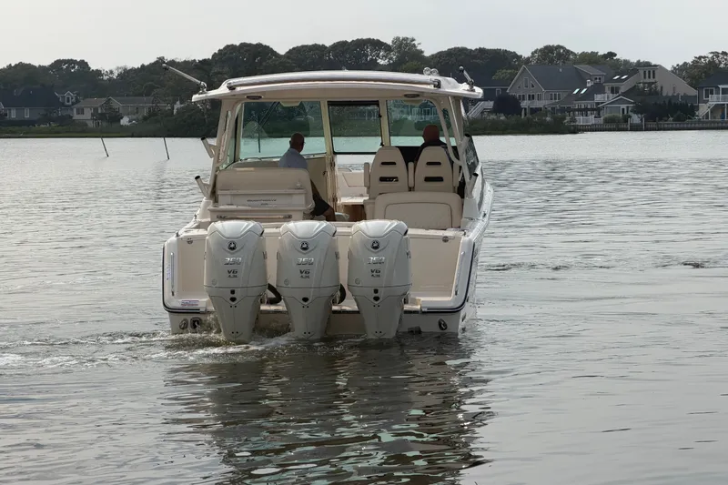 Slide: The Image of 2027 Grady-White Freedom 345 boat with triple engines on a calm lake. - 9