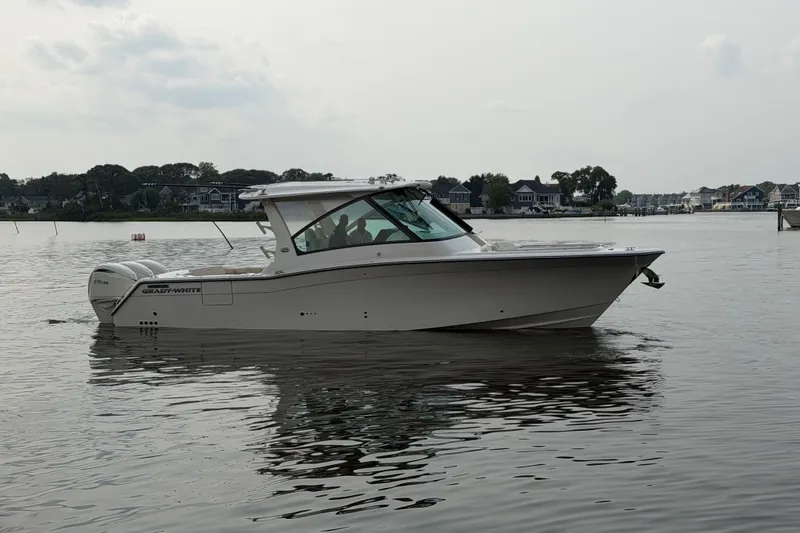 Slide: The Image of 2027 Grady-White Freedom 345 boat on calm water near residential shoreline. - 5