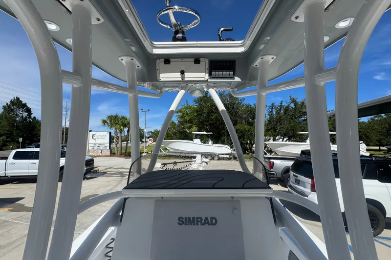Slide: The Image of 2025 BlackJack 256 Coastal boat interior with Simrad electronics, parked outdoors. - 35