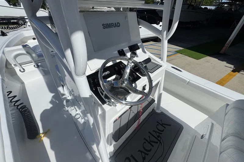 Slide: The Image of 2025 BlackJack 256 Coastal boat dashboard with steering wheel and Simrad display. - 33