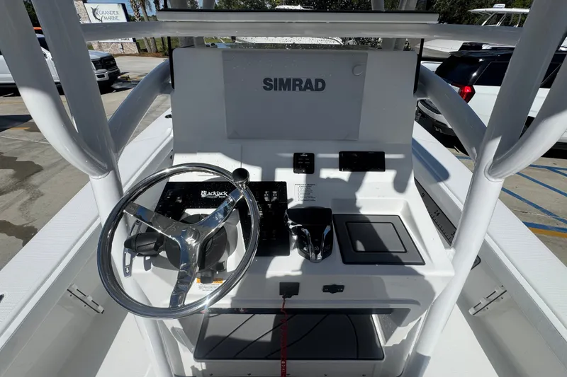 Slide: The Image of 2025 BlackJack 256 Coastal boat console with steering wheel and Simrad electronics. - 34