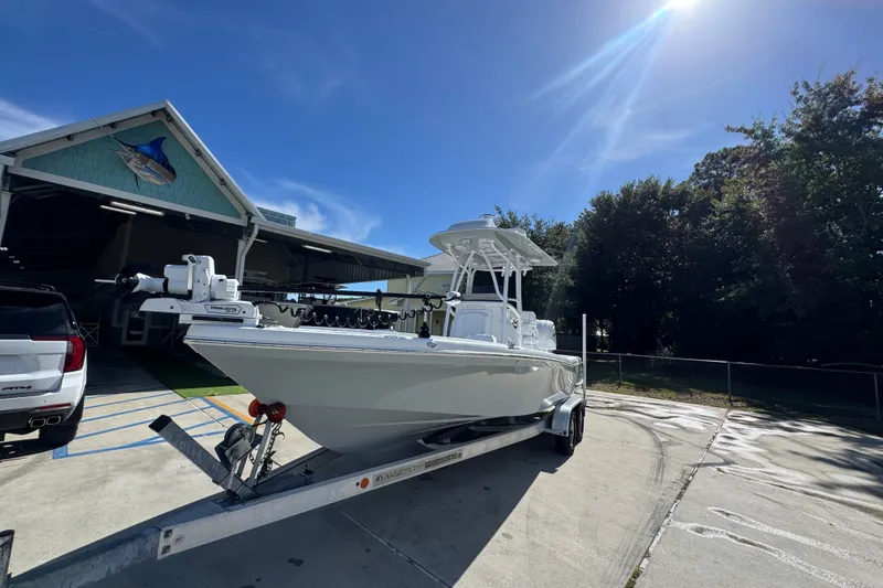 Slide: The Image of 2025 BlackJack 256 Coastal boat on trailer, parked outside a building under a clear blue sky. - 4
