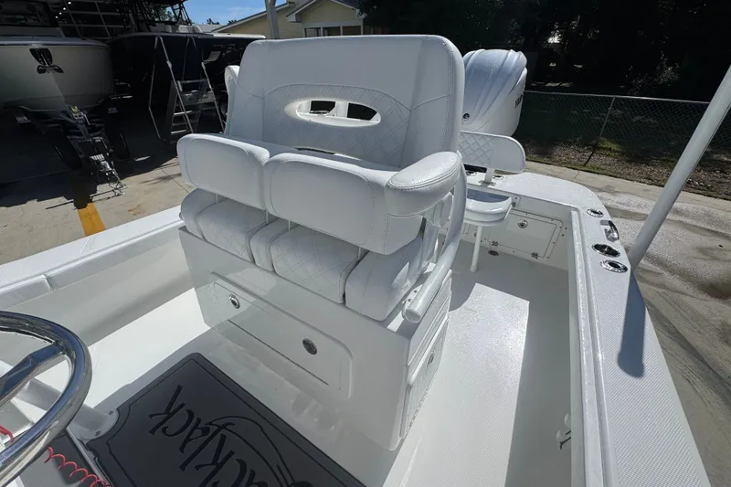 Slide: The Image of 2025 BlackJack 256 Coastal boat interior with white seating and steering wheel. - 29