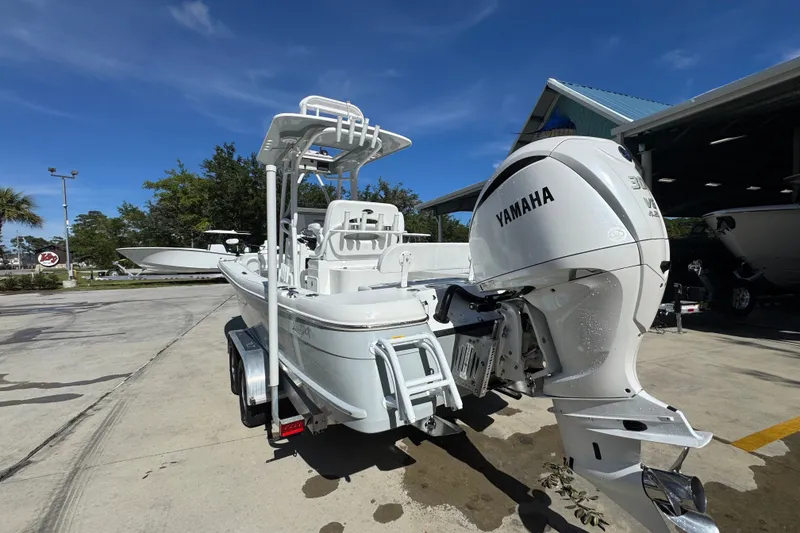 Slide: The Image of 2025 BlackJack 256 Coastal boat with Yamaha engine, parked outdoors under clear blue sky. - 13