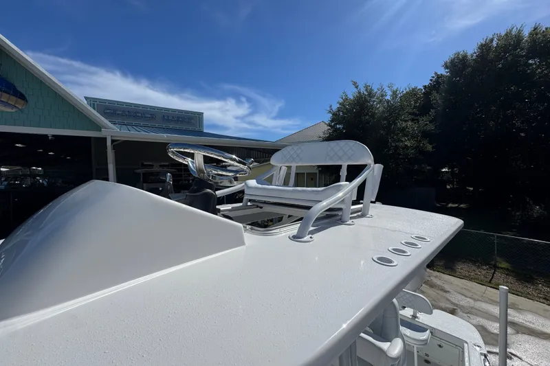 Slide: The Image of 2025 BlackJack 256 Coastal boat helm with steering wheel and seating under clear sky. - 22