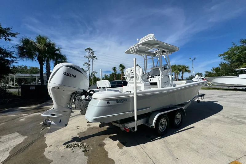 Slide: The Image of 2025 BlackJack 256 Coastal boat with Yamaha engine on trailer, parked outdoors. - 10