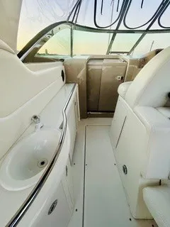 Slide: The Image of The image shows the cockpit of a 1999 Sea Ray 410 Express Cruiser with white upholstery and a sink. - 11