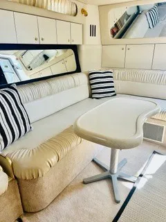 Slide: The Image of Interior of a 1999 Sea Ray 410 Express Cruiser with beige sofa and table. - 19