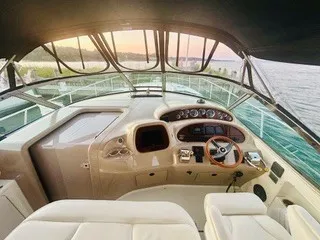 Slide: The Image of The cockpit of a 1999 Sea Ray 410 Express Cruiser with sleek seating and a modern helm. - 10