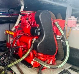 Slide: The Image of A red engine in a boat's engine compartment with hoses and cables. - 24
