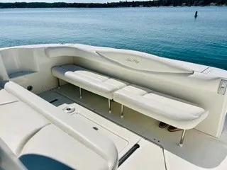 Slide: The Image of The image shows the cockpit of a 1999 Sea Ray 410 Express Cruiser with white cushioned seating. - 14