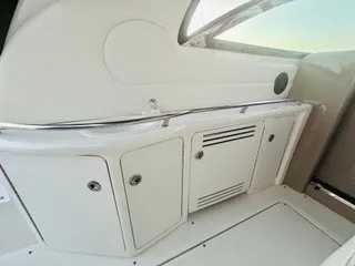 Slide: The Image of Interior view of a 1999 Sea Ray 410 Express Cruiser with white cabinets and stainless steel railing. - 12