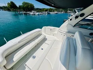 Slide: The Image of The image shows the spacious cockpit of a 1999 Sea Ray 410 Express Cruiser, with white upholstery and a view of a marina. - 2