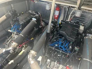 Slide: The Image of Engine room of a 1999 Sea Ray 410 Express Cruiser with two large engines and a fire extinguisher. - 23