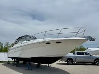 Slide: The Image of A white 1999 Sea Ray 410 Express Cruiser boat is on stands next to a pickup truck. - 1